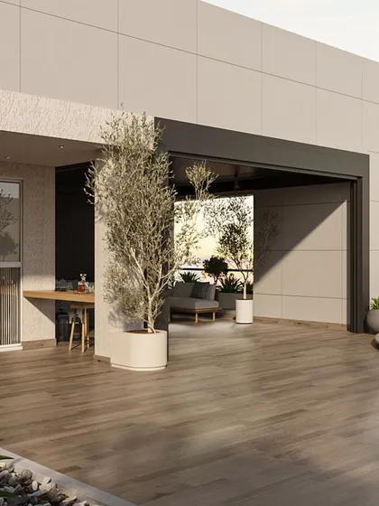 The terrace was designed as a multi-level urban oasis. This wide view shows the seamless flow from the semi-enclosed lounge to the open-air deck, with carefully placed planters and an olive tree creating a lush, green environment high above the city.