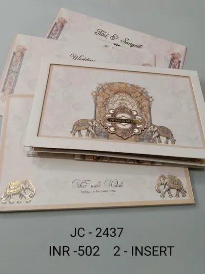 A premium off-white invitation with a framed, multi-layered design depicting a royal procession with elephants. The intricate details and 3D effect make this a truly luxurious choice.