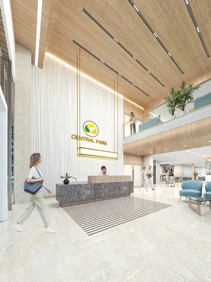 A rendering of the Central Park Polyclinic reception, featuring a dramatic double-height space and a suspended, illuminated logo. The design aims to create a memorable and uplifting arrival experience.