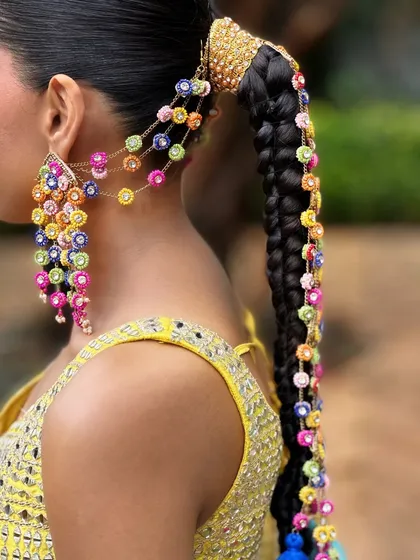 I believe hair accessories should be as joyful as the event itself. This close-up shows the vibrant, handcrafted details we used for Aish's Haldi braid. The mix of colors and textures added such a playful and personal touch to her look.