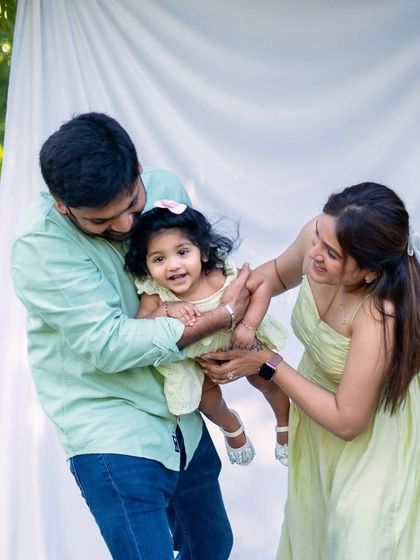 A bright and happy outdoor family photo. The pastel colors and playful interaction make this a perfect example of a fun, natural light family session.