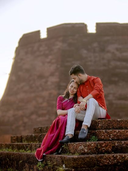 A tender moment on the steps of the historic Bekal Fort. The warm light of the setting sun creates a romantic and golden glow.