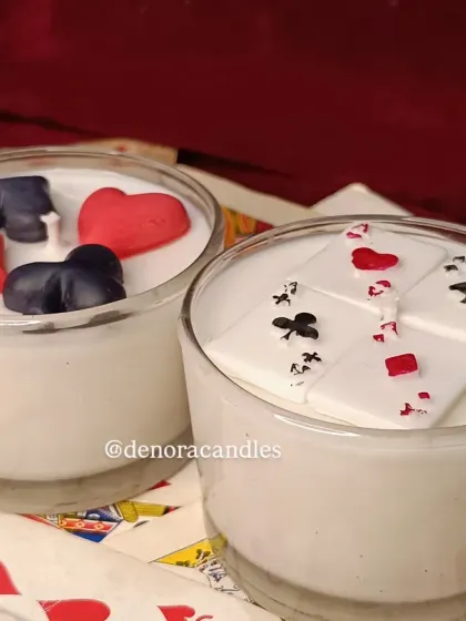 My poker candles, featuring card suits and playing cards, displayed on a bed of actual cards.