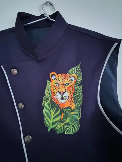 A close-up of a leopard portrait I painted on a custom jacket. I use fine brushes and high-quality acrylics to capture the intense gaze and detailed spots of the animal, turning a simple garment into a fierce statement piece.