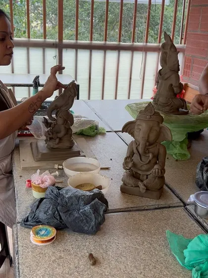 A workshop in progress, with several Ganesha idols taking shape on the table. The collective creative energy is amazing.