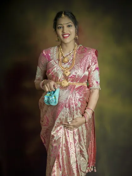 An elegant solo portrait in a traditional silk saree. The mom-to-be holds a tiny pair of baby shoes, beautifully blending cultural heritage with the anticipation of a new arrival.
