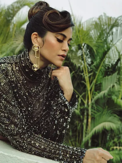 The art of elegance. A beautifully composed shot of Aaditi Pohankar, where the vintage-inspired hairstyle and dramatic earrings are paired with a classic, sculpted makeup look.