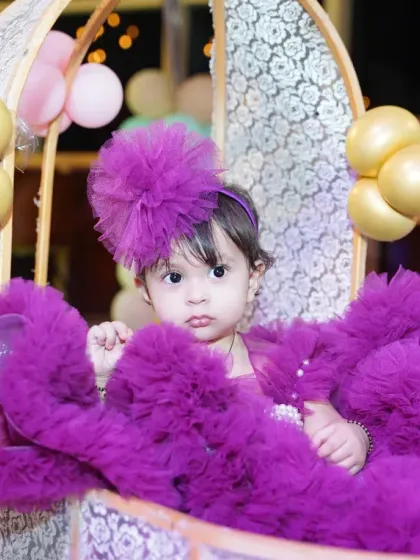 Your little one is the star of the show. We create beautiful, timeless portraits that highlight their personality, like this adorable shot of a little princess in her purple dress, sitting in a decorated carriage.