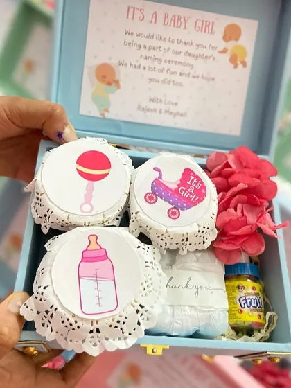 A token of thanks for your guests. These charming trunk boxes for a baby girl's naming ceremony are filled with sweet treats and keepsakes, personalized for the special day.