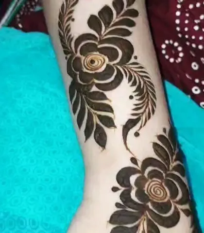 A close-up of the bold Arabic floral design on the arm. This style is perfect for someone who wants a modern and artistic henna look.