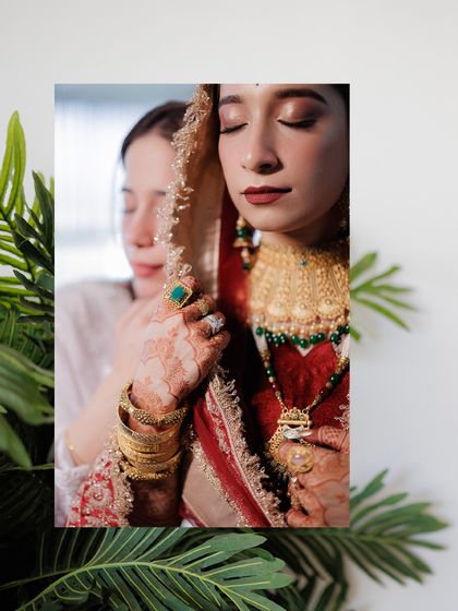 An artistic portrait of the bride, with a loved one's gentle touch, symbolizing the support and love surrounding her on her wedding day.