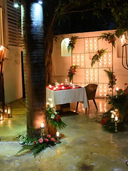 A wider view of one of our most requested romantic setups, nestled between trees and illuminated by candelabras for ultimate privacy and charm.