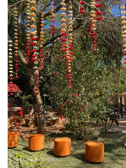 The vibrant hanging flowers on the trees created a festive and colorful canopy for the outdoor seating areas.