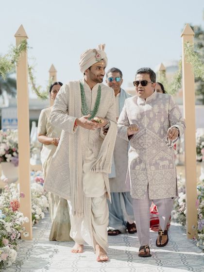 The groom's entrance, full of energy and joy, as he makes his way down the floral-lined aisle.