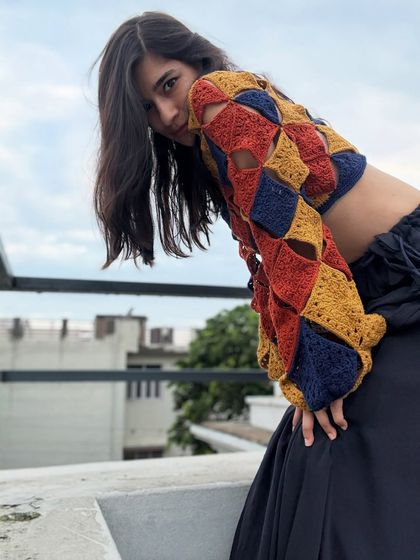 The open-shoulder detail and the way the squares connect is what makes this handmade crochet top so special. It's a design that is both airy and statement-making.