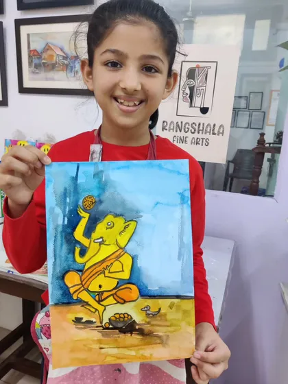 A young student proudly holds her watercolor painting of Lord Ganesha, created for the Ganesh Chaturthi festival.