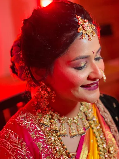 A creative shot with red lighting, highlighting the rich colors of the saree and the sparkle of the jewellery.