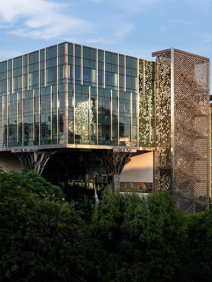 An exterior shot of the Stainless Steel Office, showing how the building is nestled within a lush green landscape. Our facade enhancements were designed to complement the existing architecture while adding a unique identity.