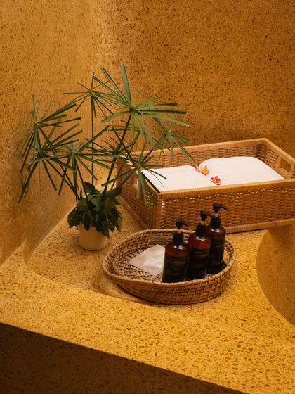 Our bathrooms are stocked with natural amenities, presented in woven baskets that complement the earthy, terrazzo sink.
