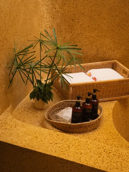 Our bathrooms are stocked with natural amenities, presented in woven baskets that complement the earthy, terrazzo sink.