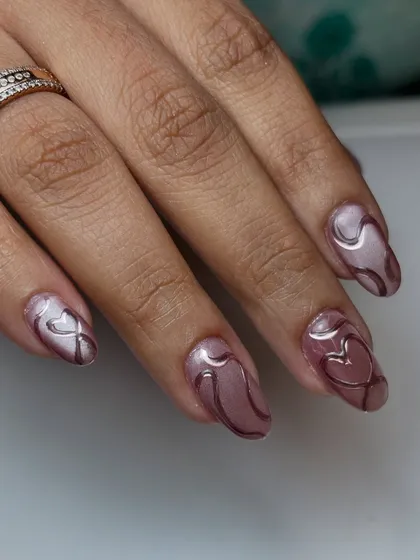 Magnetic charm with a touch of love. This design uses a dusty rose cat-eye polish as a base for delicate, 3D chrome hearts and swirls.
