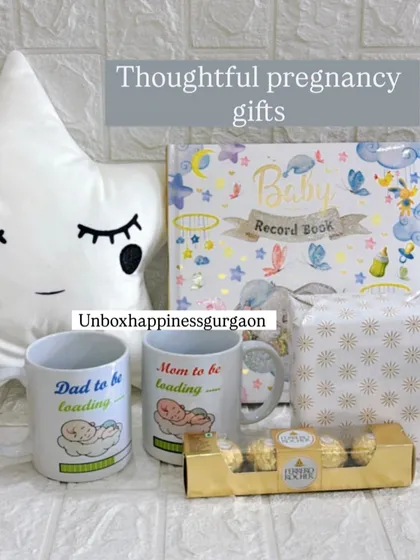 A flat lay of the thoughtful pregnancy gifts I offer, including a star cushion, parent mugs, a baby record book, and chocolates.