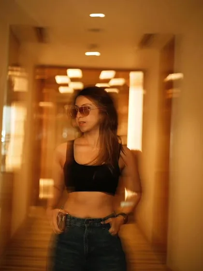 A motion-blur photo in a hotel corridor. Just a simple black crop top and jeans for a casual day.
