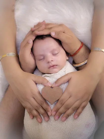 A variation of the classic newborn hands shot, with the baby wrapped snugly and parents' hands forming a heart. Each family's hands tell a different story, and I love capturing these unique details.
