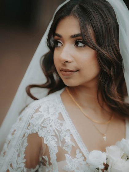 A beautiful close-up portrait of the bride. The soft focus and gentle light highlight her features and the delicate lace of her dress.