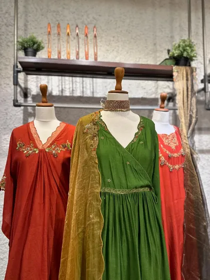 A different angle on these beautiful green and orange suits, showing the flow of the fabric and the delicate embroidery that makes each piece special.