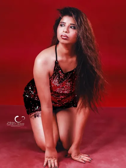 A kneeling pose with a downward glance, creating a moment of introspection amidst the glamour.
