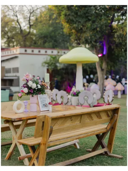A charming picnic-style table setup under a giant mushroom, continuing the playful and imaginative theme of the event.