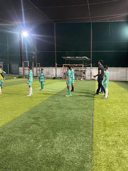 Players line up for drills during a night session. Our flexible training schedules, including sessions at top turf grounds like Prabhakar Sports Arena, accommodate school timings.