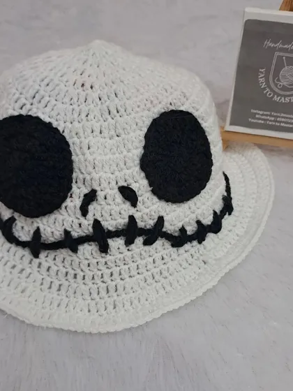 Getting ready for Halloween with this spooky-fun ghost hat. Inspired by Jack Skellington, this white bucket hat features a stitched smile and big black eyes.