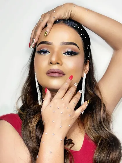 A glamorous cocktail party look with a sharp double-winged eyeliner and rhinestone details on the hands.
