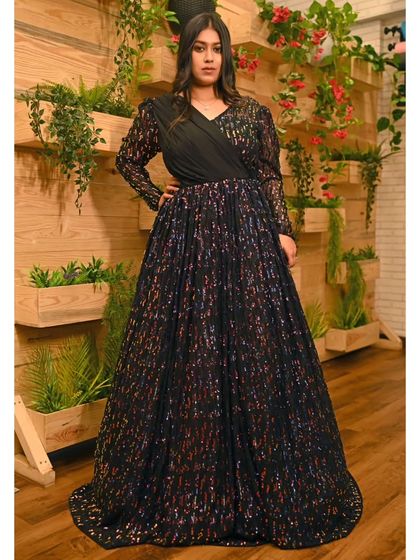 This black gown features a sequined skirt and a classic V-neck top with long sleeves. It's an elegant and sophisticated option for a formal reception or corporate event.