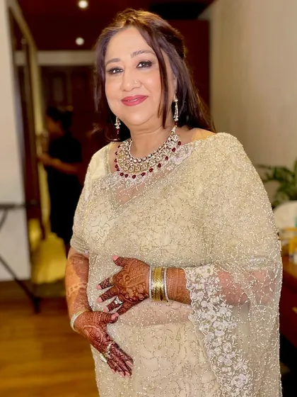 A classic and regal look for the mother of the bride. Her stunning gold saree is paired with a soft glam makeup look, featuring a subtle smokey eye and a warm nude lip.