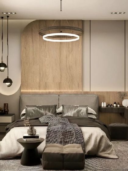 A contemporary bedroom with a unique lighting design, including a halo-style ceiling light and hanging pendants. The space features a custom bed and an integrated vanity table.