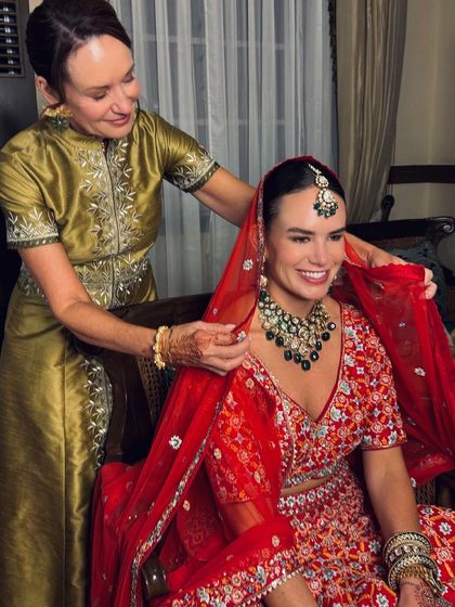 A heartwarming moment as the mother of the bride helps adjust the red dupatta. We ensure both the bride and her family feel comfortable and look their best for these precious memories.