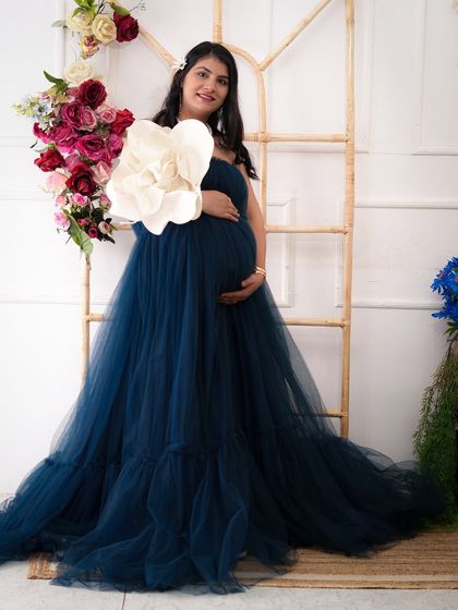 Using props like this large paper flower can add a unique and artistic touch to your maternity photos, creating a soft and dreamy feel.