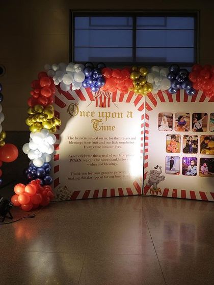 A custom backdrop designed like a vintage circus poster, displaying photos from the child's first year.