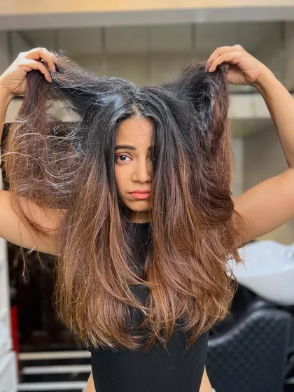 This is the "before" shot of hair that's become frizzy and lost its shape. It's the perfect canvas for a smoothing treatment and color correction to bring it back to life.