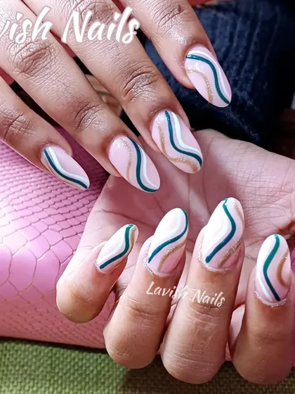 An elegant abstract swirl design using teal, white, and a hint of gold glitter on long almond nails.
