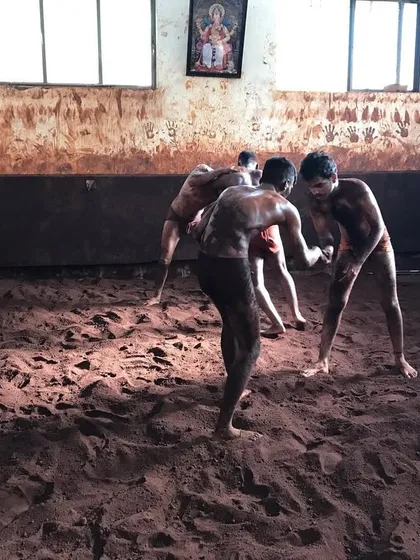 Wrestlers sparring in the mud pit. This type of practice, known as 'jod', is essential for applying techniques in a real-world scenario and building match fitness.