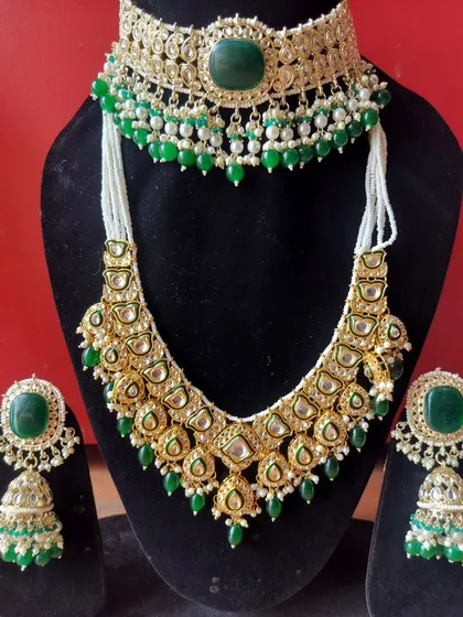 A layered Kundan set with a green choker and a longer Polki necklace, available for rent.