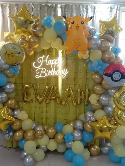 A Pokémon-themed 8th birthday party. This decoration features a circular balloon arch in yellow, blue, and gold, with Pikachu and Poké Ball foil balloons.