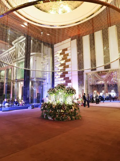 The majestic entrance to an event, where grandeur is announced from the very first step. The combination of modern architecture and classic floral arrangements sets a luxurious tone.