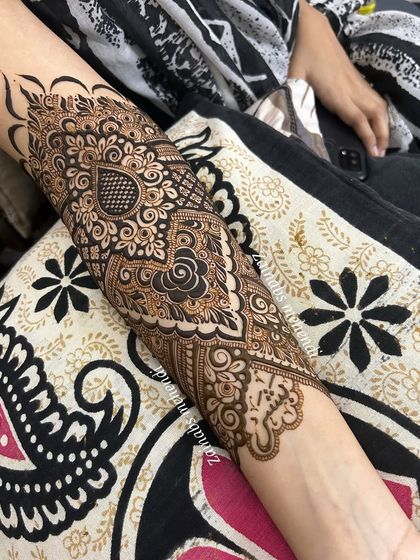 A detailed shot of Afreen's forearm, highlighting the beautiful paisley and heart motifs.
