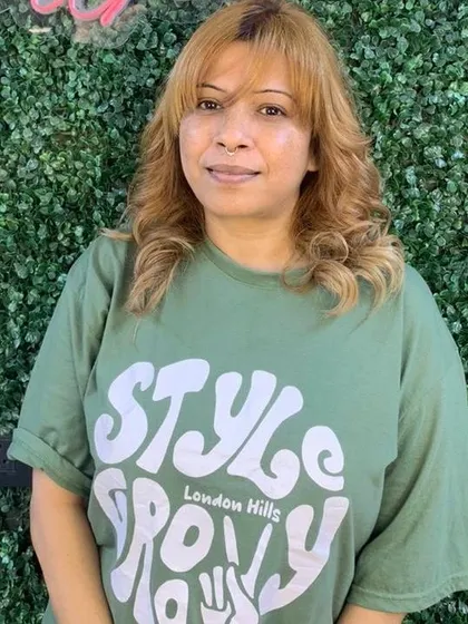 The client is all smiles with her new rose-gold hair color and fresh styling. This shows the final look and a happy customer.