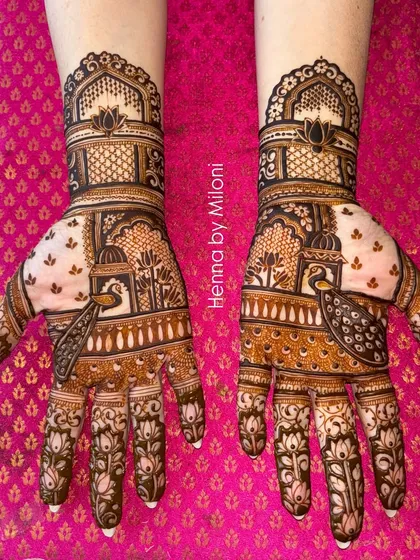 A classic Rajasthani bridal mehendi featuring intricate jharokha windows and peacock motifs. The design is symmetrical across both hands, creating a stunning, regal look for the modern bride.